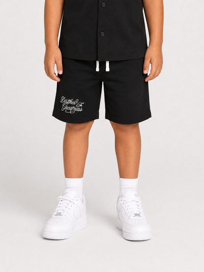 Black Jordan Craig Kids Greatness Camp shorts laid flat, showing athletic design and comfortable fit for children.