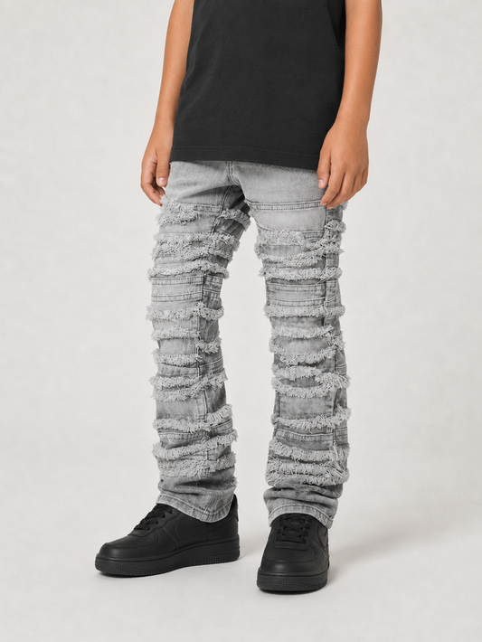 Gray distressed stacked denim jeans for kids by FWRD Kids, featuring frayed details and a relaxed fit.