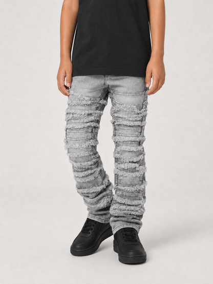 FWRD Kids distressed gray frayed stacked denim jeans showing a close-up of the distressed and frayed hem detail