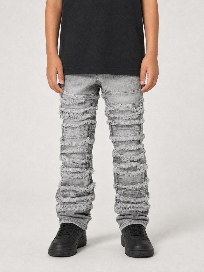 FWRD Kids distressed gray stacked denim jeans with frayed edges and a relaxed fit, showcasing casual denim style.