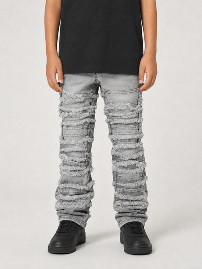 FWRD Kids distressed gray stacked denim jeans with frayed edges and a relaxed fit, showcasing casual denim style.