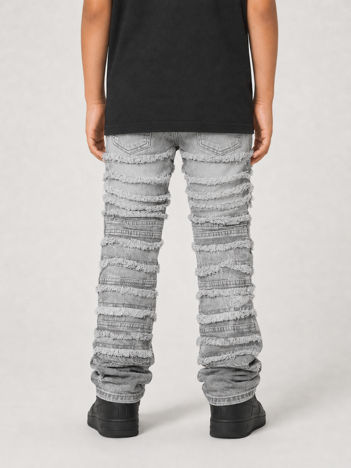 FWRD Kids gray distressed frayed stacked denim jeans with a relaxed fit, showcasing a trendy worn-in look and distressed detailing.