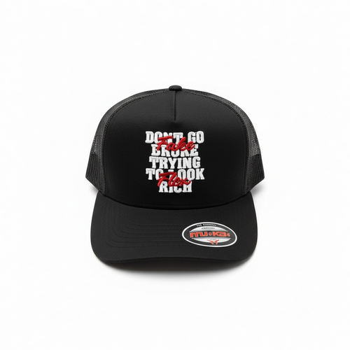Black MUKA Fake Flex trucker hat with mesh back and curved brim, featuring the brand logo on the front panel.