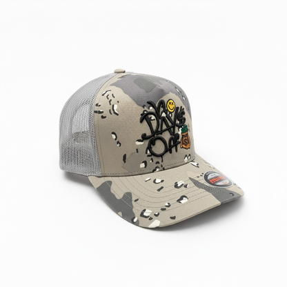 Gray desert camo MUKA 'No Days Off' trucker hat with mesh back and curved brim, casual accessory for everyday wear.