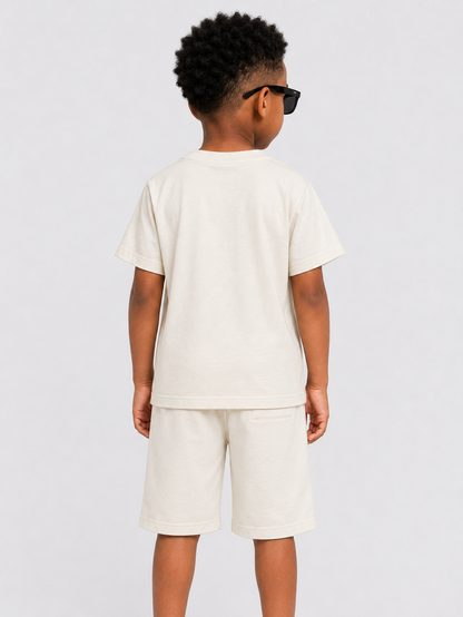 Cream Rebel Minds Kids 'Paradise' T-shirt featuring a colorful paradise design on the front.