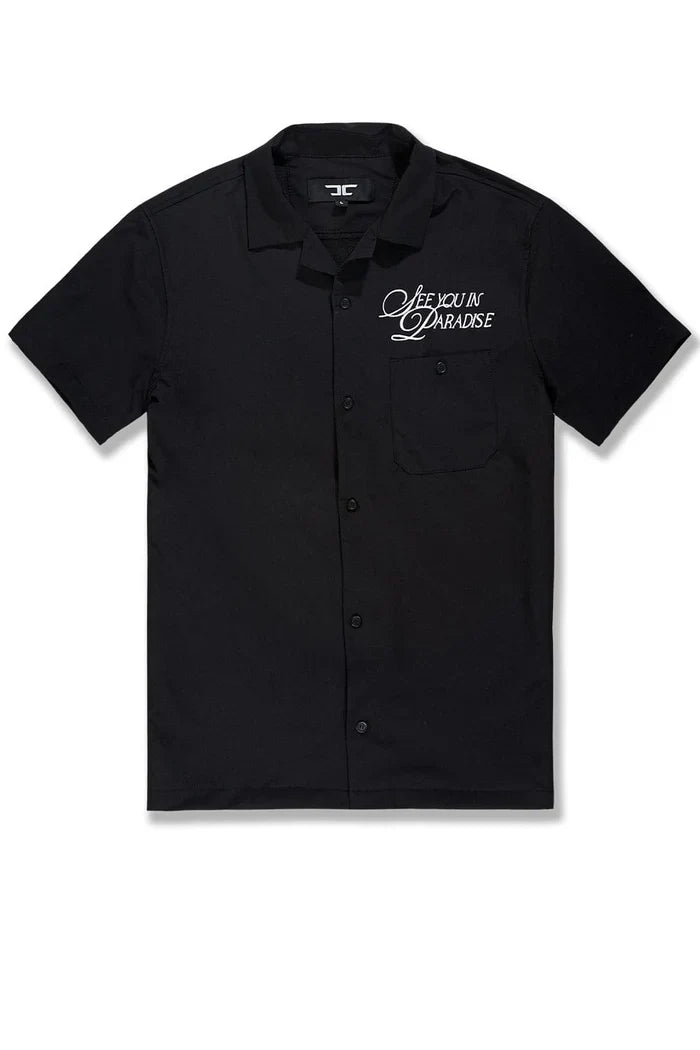 Black SYIP 'See You in Paradise' short sleeve button-up crewneck shirt displayed on a model with a casual fit.