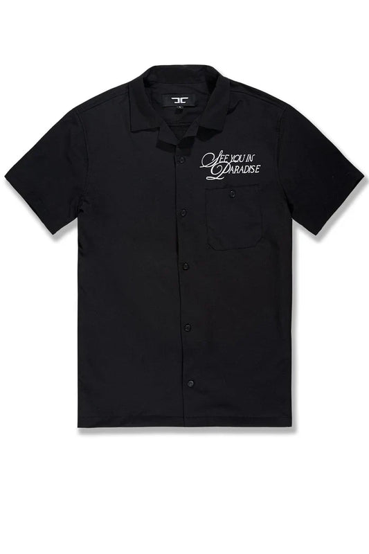 Black SYIP 'See You in Paradise' short sleeve button-up crewneck shirt displayed on a model with a casual fit.
