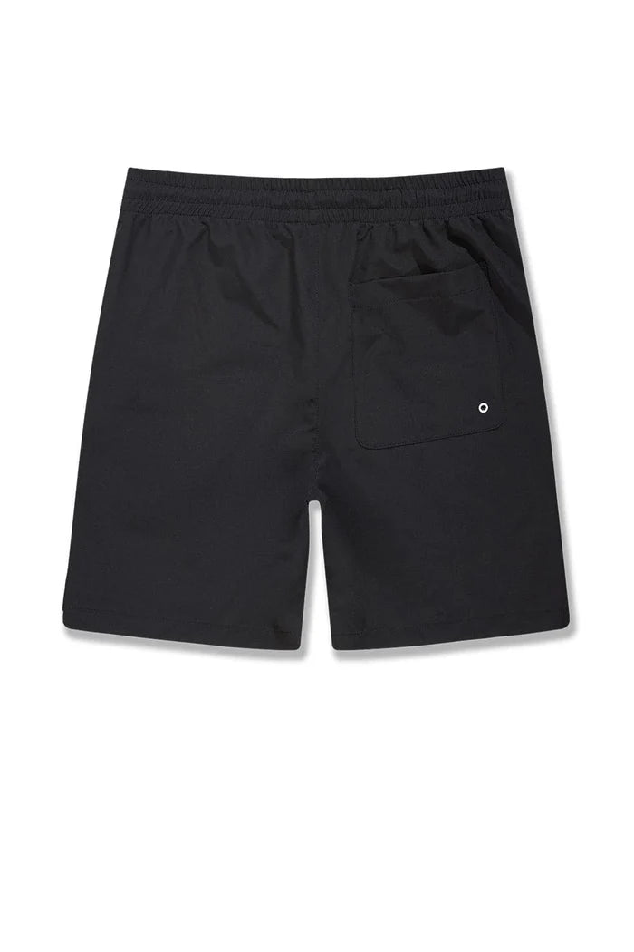 Black SYIP 'See You in Paradise' shorts laid flat, showcasing their relaxed fit and minimalistic design.