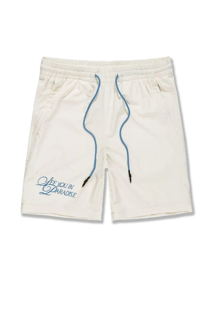 Cream SYIP 'See You in Paradise' shorts with a relaxed fit, displayed on a model, showcasing the casual style and fabric details.