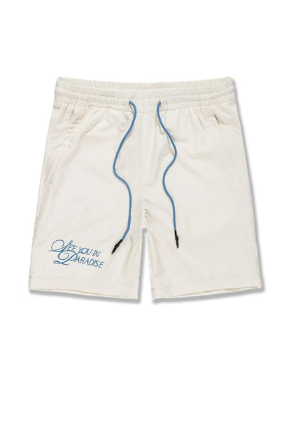 Cream SYIP 'See You in Paradise' shorts with a relaxed fit, displayed on a model, showcasing the casual style and fabric details.