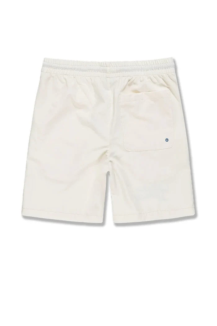 SYIP 'See You in Paradise' cream shorts with a relaxed fit, displayed on a hanger against a neutral background.