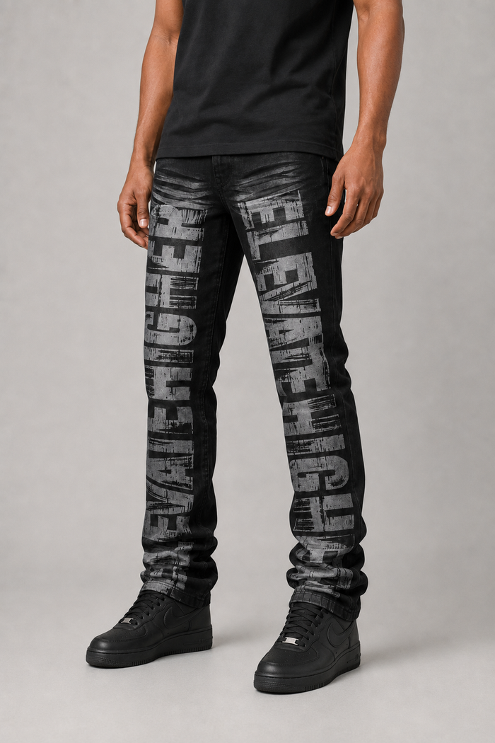 Taker all-over print premium stretch stacked denim jeans in black ash with detailed stitching and design elements.